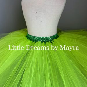 K&ouml;nnte beinhalten: Ein limettengr&uuml;ner T&uuml;ll-Tutu-Rock mit einem gr&uuml;nen H&auml;kelbund. Der Rock befindet sich auf einer wei&szlig;en Kleiderpuppe. Der Text "Little Dreams by Mayra" ist auf den Rock gedruckt.