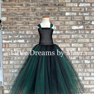 May include: A floor-length dress featuring a black crocheted bodice with dark green shoulder straps and a voluminous skirt made of layered black and dark green tulle. The text Little Dreams by Mayra is printed across the center of the image.