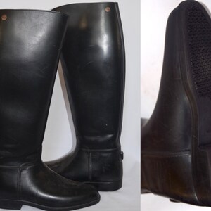 May include: A pair of black leather riding boots with a zipper on the back of the boot. The boots have a rubber sole with a textured tread.