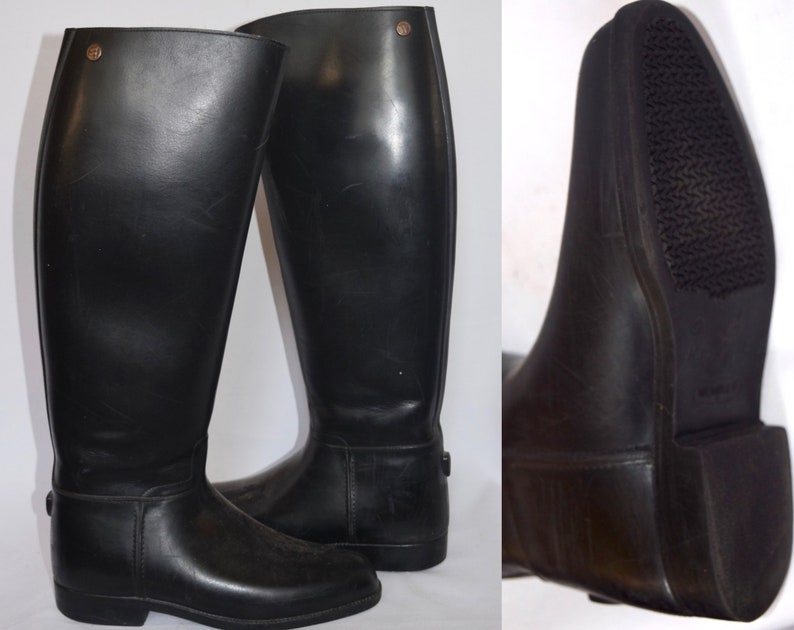May include: A pair of black leather riding boots with a zipper on the back of the boot. The boots have a rubber sole with a textured tread.