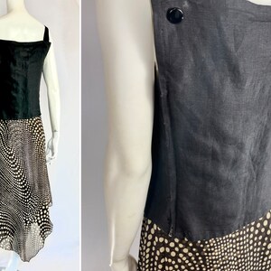 May include: A black sleeveless top with wide straps and a black and white polka dot skirt. The top has a square neckline and a button detail on the back. The skirt has an asymmetrical hemline.