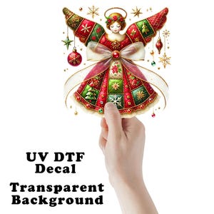 May include: A colorful Christmas angel decal with a transparent background. The angel is wearing a red and green patchwork dress and wings, with a halo and a bow. The text "UV DTF Decal Transparent Background" is at the bottom.