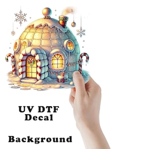 May include: A festive igloo-shaped house decal featuring a snow-covered roof, glowing yellow windows, and candy cane pillars on each side. The design includes hanging snowflakes and ornaments, with the text UV DTF Decal Background printed below.