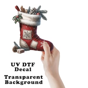 May include: A red Christmas stocking with white trim, decorated with patches and snowflakes. The stocking is filled with pinecones, greenery, and a small gift. The text "UV DTF Decal Transparent Background" is visible.