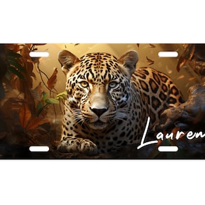 May include: A close-up of a leopard with a spotted coat, lying on a branch in a jungle setting. The leopard's eyes are open and looking directly at the viewer. The name "Lauren" is written in white cursive script on the right side of the image.