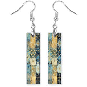 May include: A pair of silver dangle earrings with rectangular blue and gold patterned charms. The pattern features geometric shapes and floral designs.