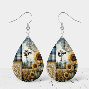 May include: A pair of teardrop-shaped earrings with a farmhouse theme. The earrings feature a blue and white plaid pattern, a windmill, and sunflowers. The earrings are made of metal and have silver hooks.
