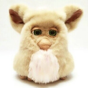 Peut inclure: Un jouet en peluche beige et blanc avec de grands yeux verts et un nez rose. Le jouet a un ventre blanc moelleux et de grandes oreilles.