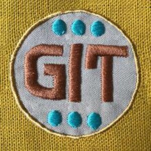 Könnte beinhalten: Ein blauer und brauner gestickter Aufnäher mit den Buchstaben "GIT" in Braun und vier türkisfarbenen Punkten am Rand.
