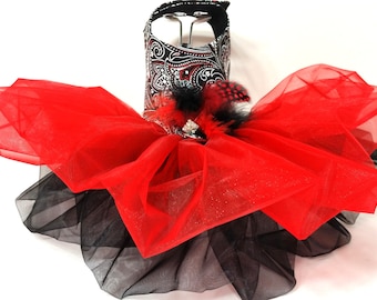 May include: A red and black tulle tutu with a paisley print bodice and a rhinestone embellishment. The bodice has a black and silver paisley print with rhinestones. The tutu is layered with red and black tulle.