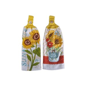 Puede incluir: Dos toallas de cocina de crochet amarillo con dise&ntilde;os de girasoles. Una toalla presenta un solo girasol con el texto "Summer" y "Fig. I." La otra toalla presenta un ramo de girasoles en un frasco de vidrio con flores rojas y naranjas.