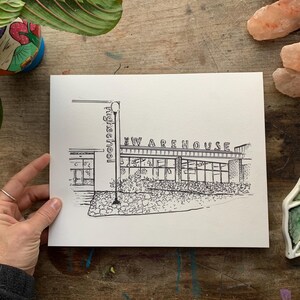 May include: Black and white line drawing print of a building with the text "Warehouse" above the entrance and "High School" on the side.