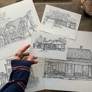 May include: A set of five black and white ink drawings of houses. Each drawing is on a separate piece of white paper. The drawings are all in a similar style, with detailed lines and shading.