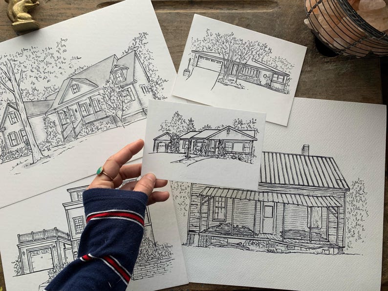 May include: A set of five black and white ink drawings of houses. Each drawing is on a separate piece of white paper. The drawings are all in a similar style, with detailed lines and shading.