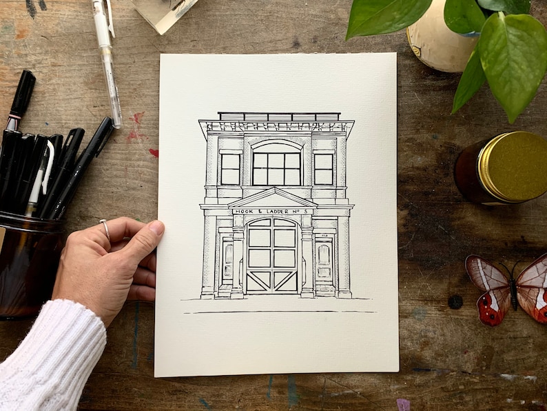 K&ouml;nnte beinhalten: Schwarz-wei&szlig;-Zeichnung eines Geb&auml;udes mit dem Text "HOOK & LADDER NO. 5" &uuml;ber dem Eingang. Das Geb&auml;ude hat zwei Fenster im zweiten Stock und ein gro&szlig;es Garagentor im Erdgeschoss.