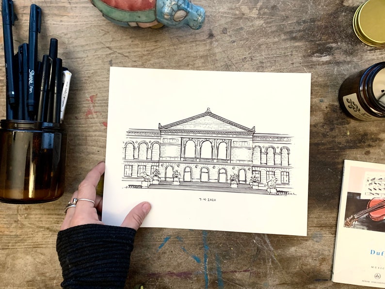 May include: A black and white line drawing of a building with a large arched entrance and multiple windows. The drawing is on a white piece of paper and the text "The Edge" is written below the building.