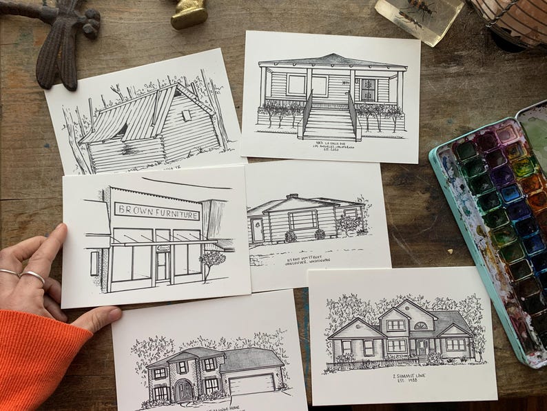 May include: Five black and white line drawings of different buildings on white card stock. The drawings are of a house, a store, and three different homes. The drawings are all done in a simple style and are very detailed.