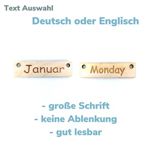 May include: Two wooden tags with holes for hanging. The tag on the left says "Januar" and the tag on the right says "Monday". The text is in a large, easy-to-read font.