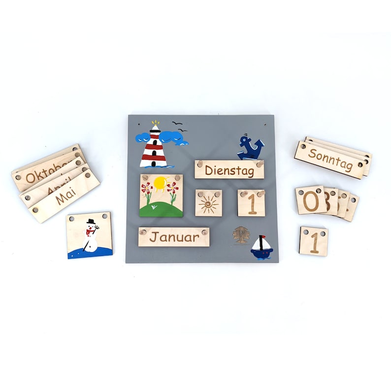 May include: A wooden calendar with a gray background and colorful illustrations. The calendar includes months, days of the week, and numbers. The calendar is designed for children and features a snowman, a lighthouse, a sun, and an anchor.