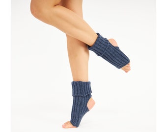 May include: A pair of dark blue, ribbed knit yoga socks featuring an open-toe and open-heel design. These socks have a thick, folded cuff at the ankle, providing a secure fit while leaving the toes and heels exposed for better grip and stability.