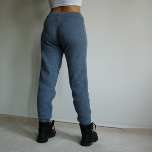 Back view of denim blue knitted leggings showing the fitted high waist, smooth seat and full-length silhouette.