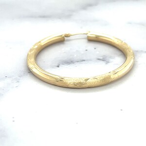 14K Yellow Gold Diamond Cut Textured Design Hoop Earring photographed on its own