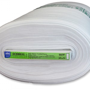 May include: A roll of white Pellon Fusible Fleece fabric. The label indicates it is 100% polyester and machine washable. The roll is labeled "987F".