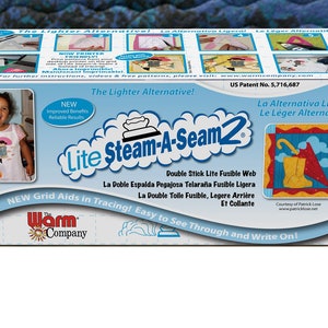 May include: A box of Lite Steam-A-Seam2 fusible web, a lighter alternative to traditional fabric glue. The box features a girl wearing an apron, a close-up of the product, and a red umbrella with a yellow rain boot. The text on the box reads "Lite Steam-A-Seam2", "The Lighter Alternative!" and "US Patent No. 5,716,687".