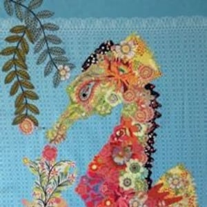 以下が含まれることがあります： 布の切れ端で作られた、カラフルで手作りのタツノオトシゴの壁掛け。タツノオトシゴは花柄のディテールと青い背景に囲まれています。