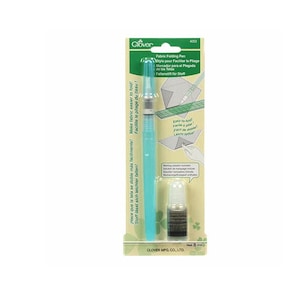 May include: A green and blue fabric folding pen with a bottle of marking solution. The pen is labeled "Fabric Folding Pen" and "Easy-to-fold!" The bottle is labeled "Net 8 ml".