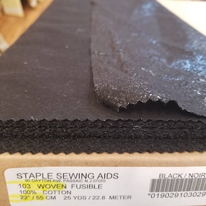 Puede incluir: Tela fusible negra tejida para coser. La etiqueta dice "103 Woven Fusible, 100% Algodón, 22"/55 cm, 25 yds/22,8 metros, Negro/Noir, *019029103029".