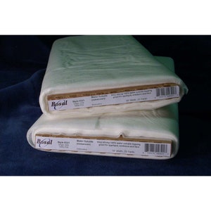 May include: Two rolls of white water soluble stabilizer fabric. The label reads "Bosal Style #321 Origin: USA 100% PVA Water Soluble (nonwoven) Embroidery Very strong 100% water soluble topping great for applique, emblems and lace 19" Width, 25 Yards".