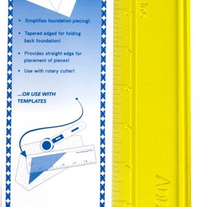 May include: A yellow Add-A-Quarter Plus ruler with a blue and white informational card. The ruler has inch markings and is designed for foundation piecing. The card details features like simplifying piecing and using with templates.