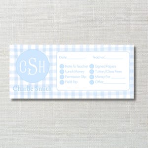May include: A light blue and white gingham-patterned note card with the name "Charlie Smith" and initials "CSH" in a circle. The card includes fields for date, teacher, and checkboxes for various school-related items.