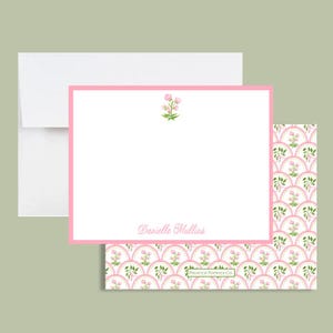 May include: A stationery set featuring a white envelope, a pink-bordered notecard, and a patterned card. The notecard has a floral design and the name "Danielle Mullins" printed in script. The patterned card has a scalloped design with floral accents.