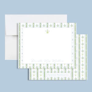 May include: White stationery with a blue and green floral border. The stationery has a small floral design in the top center and the name "Danielle May Miller" printed at the bottom. The bottom right corner has the text "PRINTED POPPIES CO."