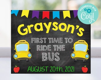 May include: A chalkboard sign with the text "Grayson's First Time to Ride the Bus August 20th, 2021". The sign is decorated with colorful pennants, two yellow school buses, and red apples.