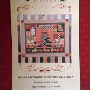 May include: A brochure for a patchwork Christmas wall quilt, designed by Mary Asper. The quilt design features a Christmas tree, snowman, and presents. The brochure is approximately 42 x 34 inches.