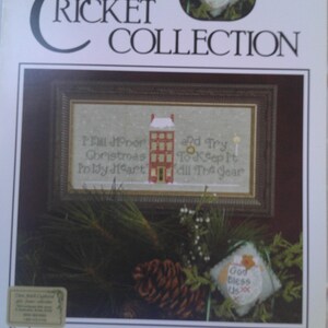 May include: Cross stitch pattern for a Christmas house with the text "I'll Honor Christmas In My Heart And Try To Keep It All The Year". The pattern is from The Cricket Collection, No. 288, and is titled "Dickens' Mittens-The Last Word" by Vicki Hastings.