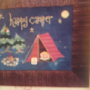 Puede incluir: Un diseño de punto de cruz enmarcado con una tienda de campaña roja, dos árboles y el texto "happy camper".