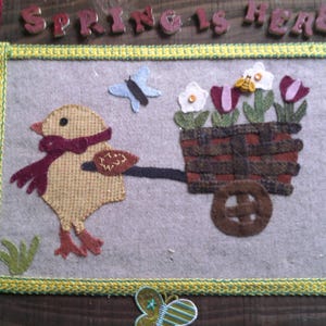 La primavera ya está aquí con el pollito y su carro lleno de flores para colgar en la pared.