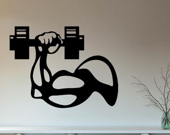 May include: Black and white silhouette of a bicep lifting a dumbbell. The image is on a white wall above a wooden cabinet.