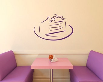 May include: A purple cake silhouette on a plate, with a simple design, is on a light beige wall. Two purple chairs and a pink table with a small orange flower arrangement are in the foreground.
