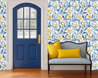 May include: A blue door with a window is framed by a white door frame. The walls are covered in a floral wallpaper with blue leaves and yellow flowers. A small blue bench with yellow cushions sits in front of the wall.