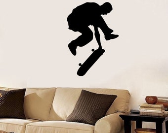May include: Black silhouette of a person performing a skateboard trick. The person is in mid-air, with one leg extended and the other bent, and is holding a skateboard with their feet. The skateboard is in the air, with the wheels facing down.