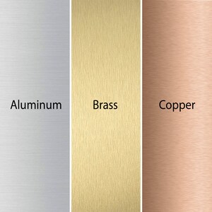 K&ouml;nnte beinhalten: Nahaufnahme von drei geb&uuml;rsteten Metallproben: Aluminium, Messing und Kupfer. Jede Probe hat eine eigene Farbe und Textur.