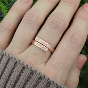 May include: Rose gold-colored ring with the words "Enjoy the Journey" engraved on it.
