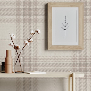 May include: A beige and white plaid wallpaper with a wooden frame picture of a simple line drawing of a plant. A shelf with a vase of cotton stems, a brown bottle, and a wooden tray with a brown bowl on top.