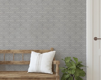 May include: A gray wallpaper featuring a repeating white geometric diamond pattern. The wallpaper is displayed on a wall behind a wooden bench with a white pillow, a green potted plant, and a white door with a brown handle.