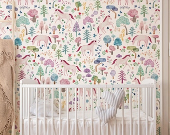 Peut inclure: Un lit bébé blanc avec une jupe blanche et deux coussins en forme de cœur rayés est placé contre un mur recouvert de papier peint à motif répétitif de licornes roses, d'arbres colorés et de fleurs sur un fond de couleur crème.